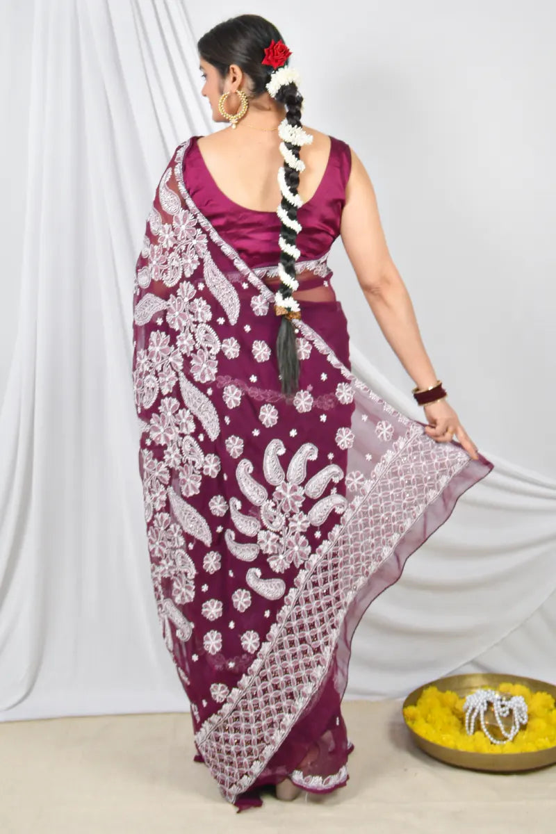 Handcrafted Wine Georgette saree with intricate Lucknowi Chikankari embroidery and a matching blouse, ideal for festive and wedding occasions.