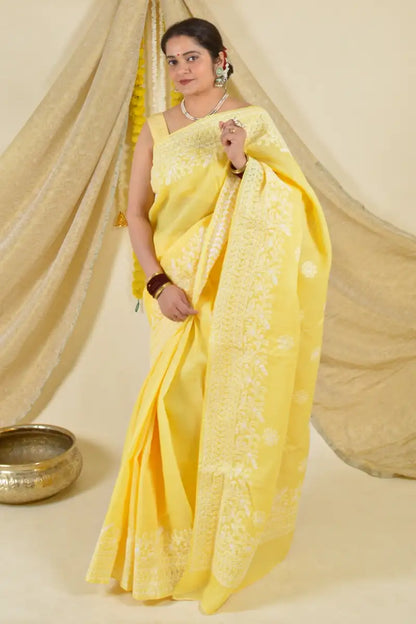 Handcrafted Yellow Cotton saree with intricate Lucknowi Chikankari embroidery and matching blouse, ideal for weddings and festive occasions.

