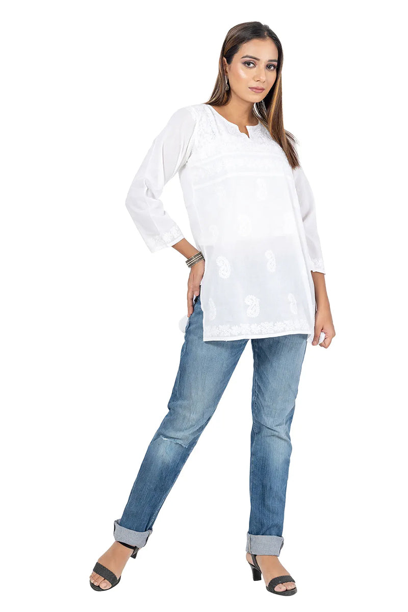 Woman wearing Fabnuma Handcrafted Chikankari White Short Cotton Kurti paired with jeans and black heels.