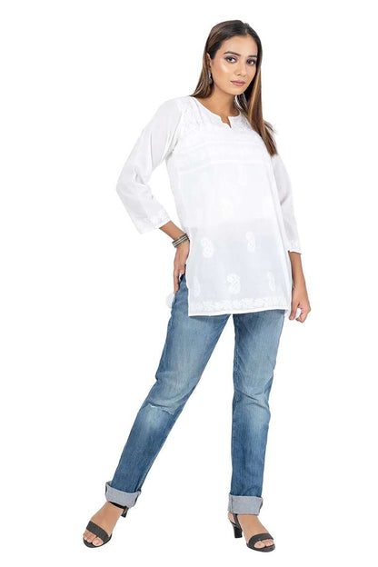 Woman wearing Fabnuma Handcrafted Chikankari White Short Cotton Kurti paired with jeans and black heels.
