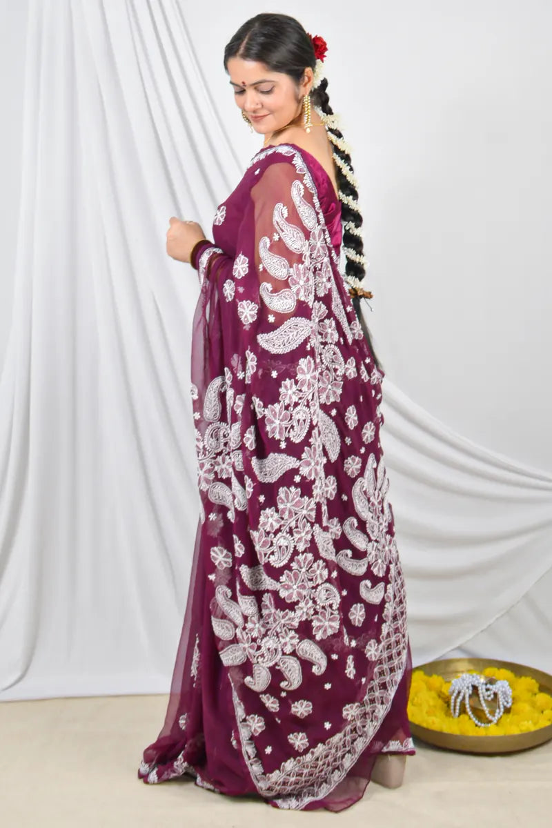 Handcrafted Wine Georgette saree with intricate Lucknowi Chikankari embroidery and a matching blouse, ideal for festive and wedding occasions.
