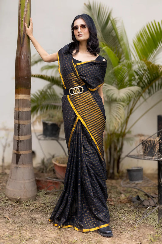 Model wearing a black and gold designer saree with a modern draped style suitable for festive and party wear.