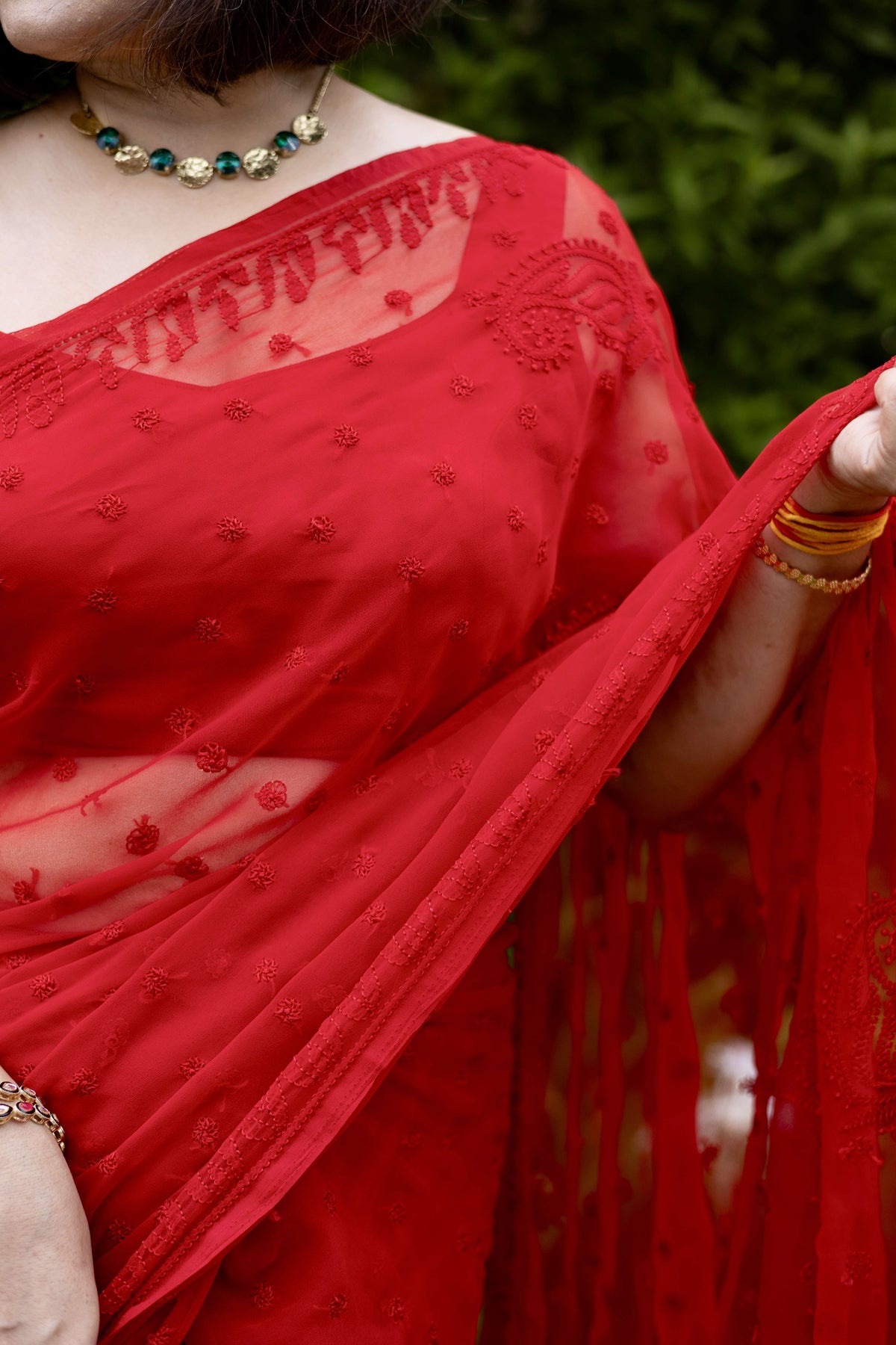 Close-up of red georgette Lucknowi chikankari hand embroidery on saree blouse neckline