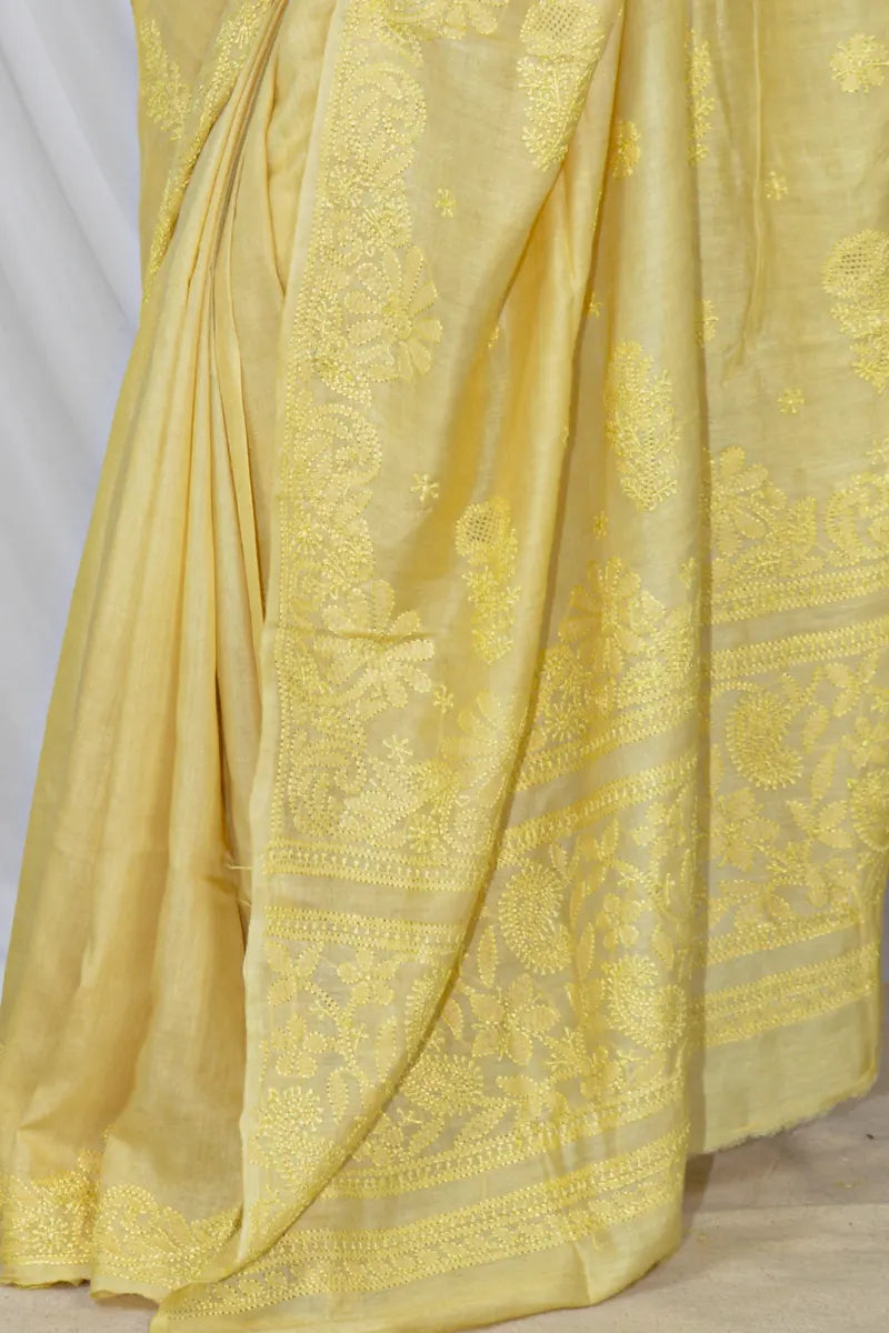 Handcrafted yellow Tussar silk saree with intricate Lucknowi Chikankari embroidery and a matching blouse, ideal for festive and wedding occasions
