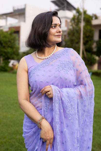 Woman in lavender georgette chikankari saree with blouse, side profile in garden