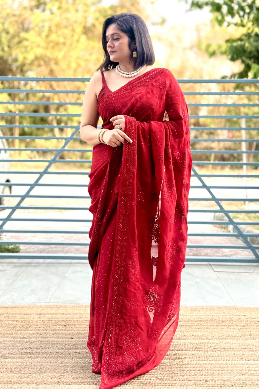Red organza chikankari saree with mukaish work, includes blouse, ideal for festive occasions.