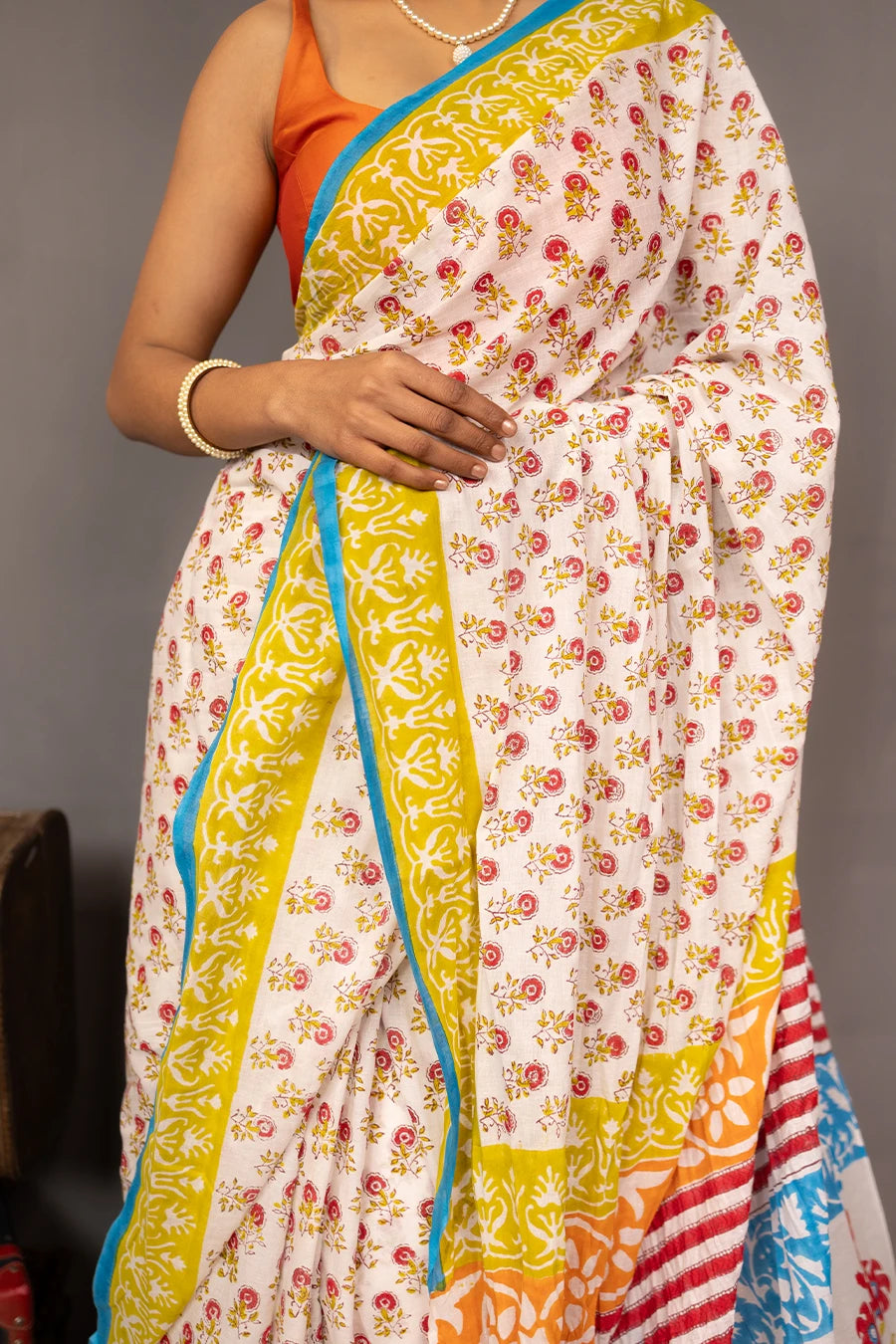 Woman wearing a colorful saree with a grey background