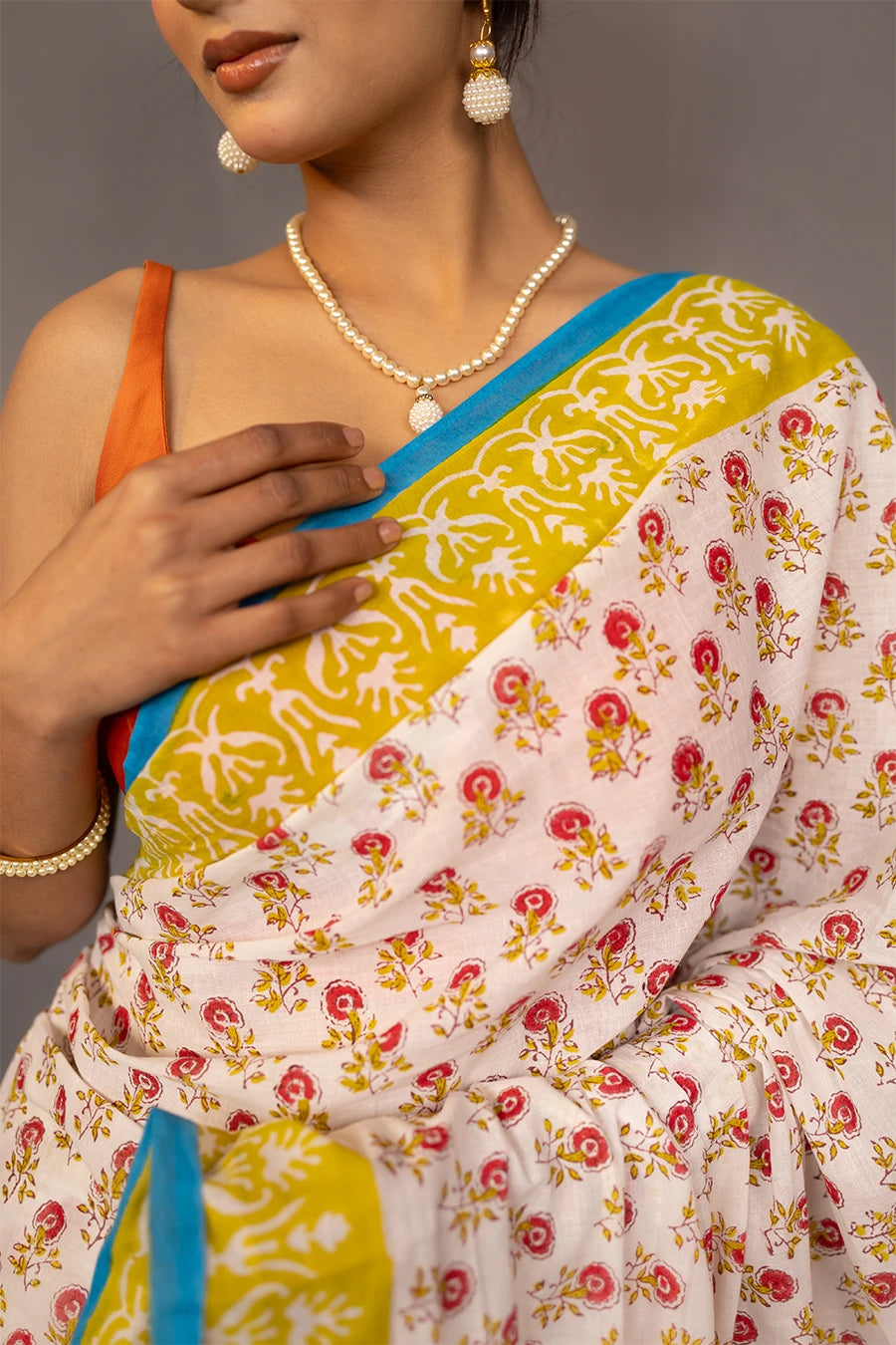 Woman wearing a colorful saree with a grey background